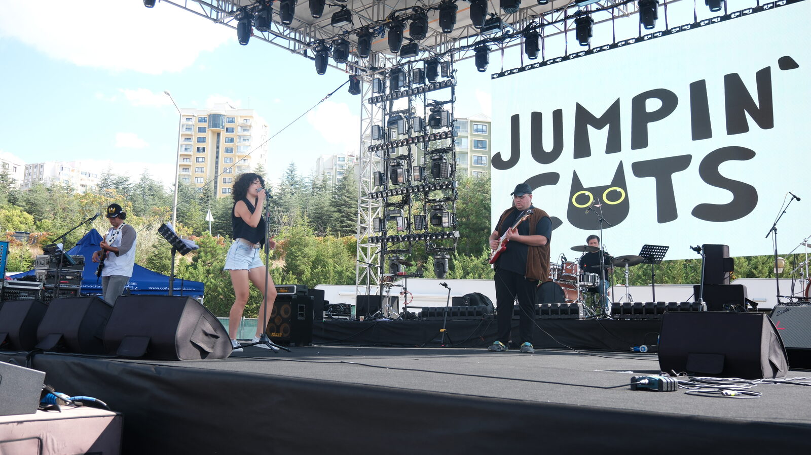 A band on the open-air stage in front of the festival backdrop