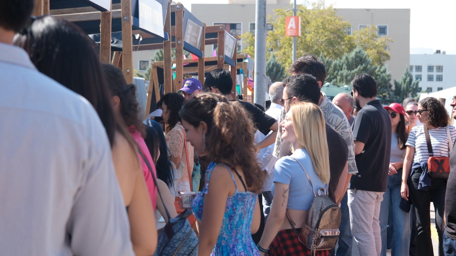A crowd at the stalls on a bright afternoon