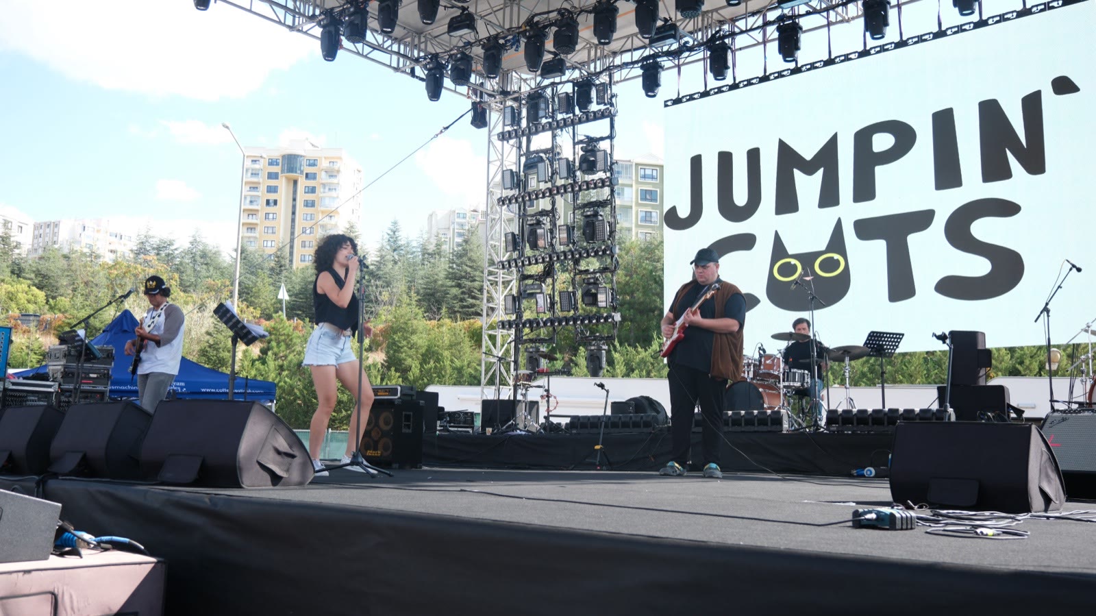 A band on the daytime stage with the city behind