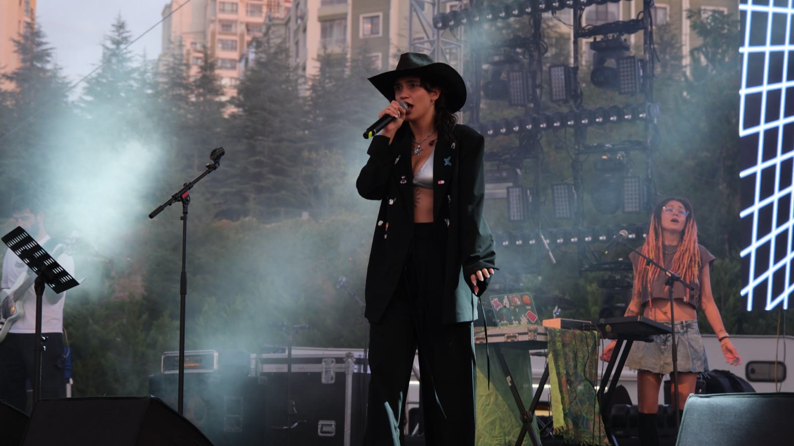 A singer in a hat on the stage in soft light