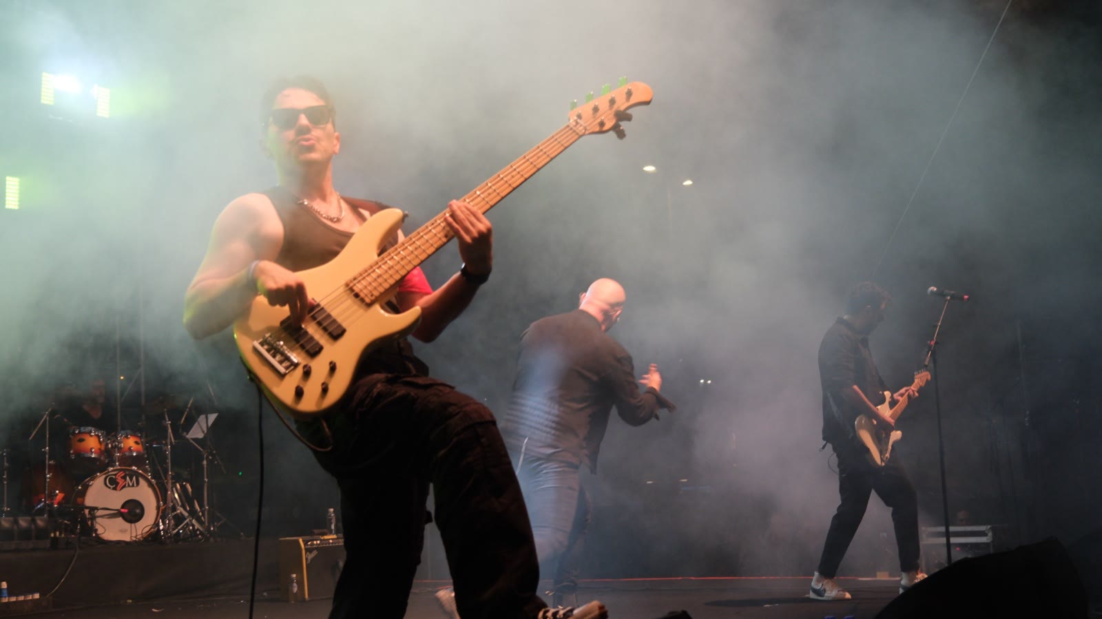 A bass player up front in stage smoke