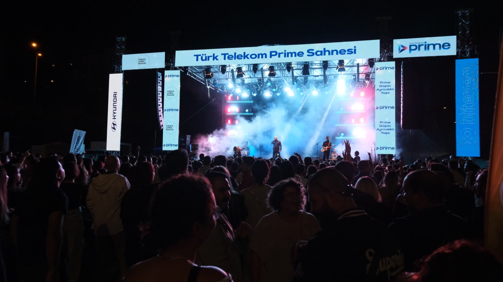 The lit stage at night, the crowd from behind