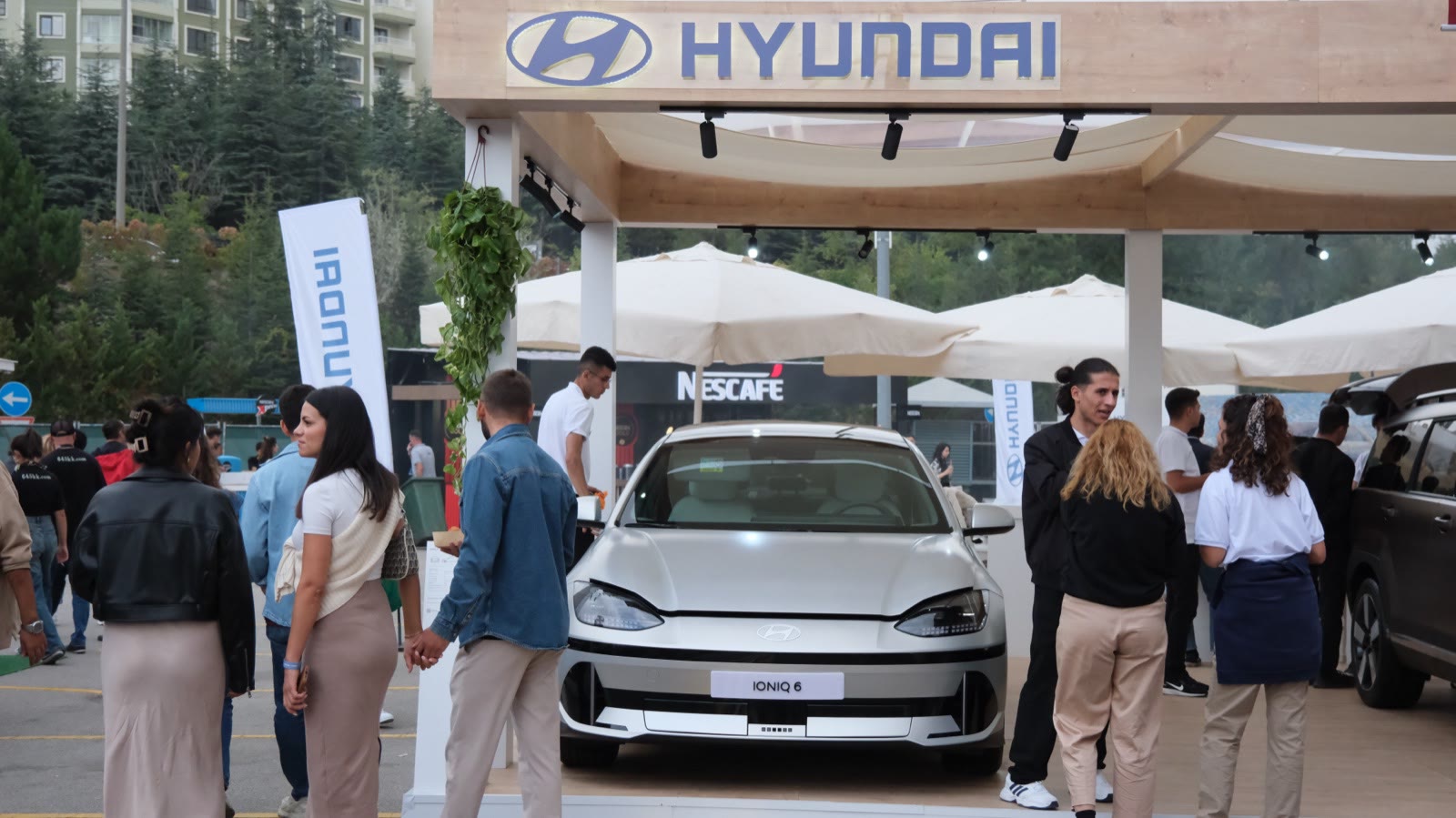 An electric car on a sponsor's stand, visitors around