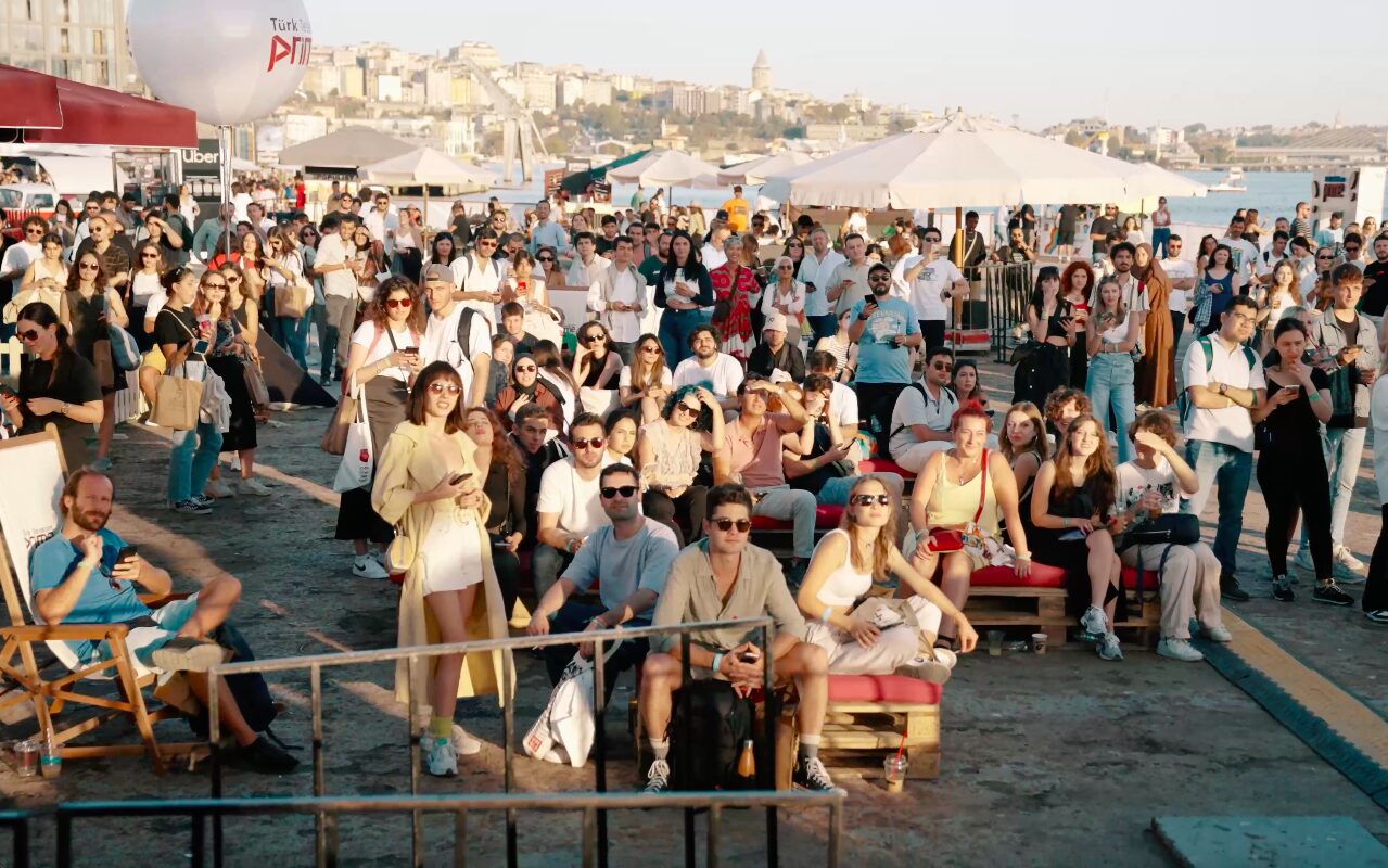 A dense daytime crowd on the steps above the festival