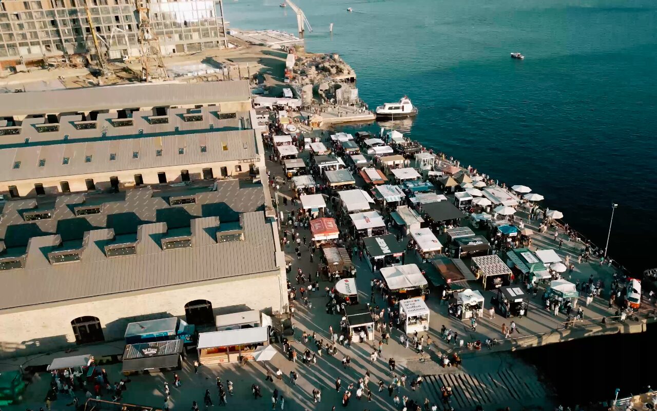 The waterfront site from above, a pier lined with stands