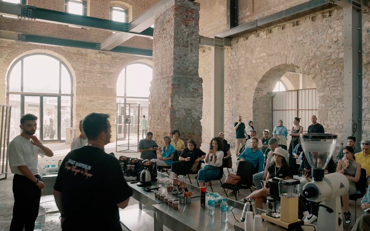 A brewing bar under stone arches, visitors standing along the counter