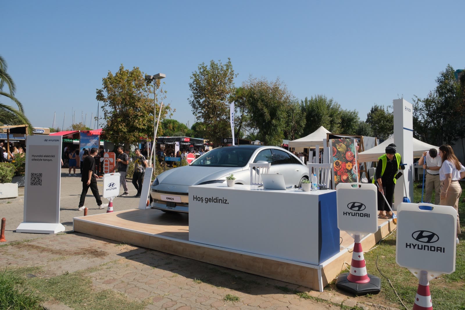 An electric car on a sponsor's stand between the trees