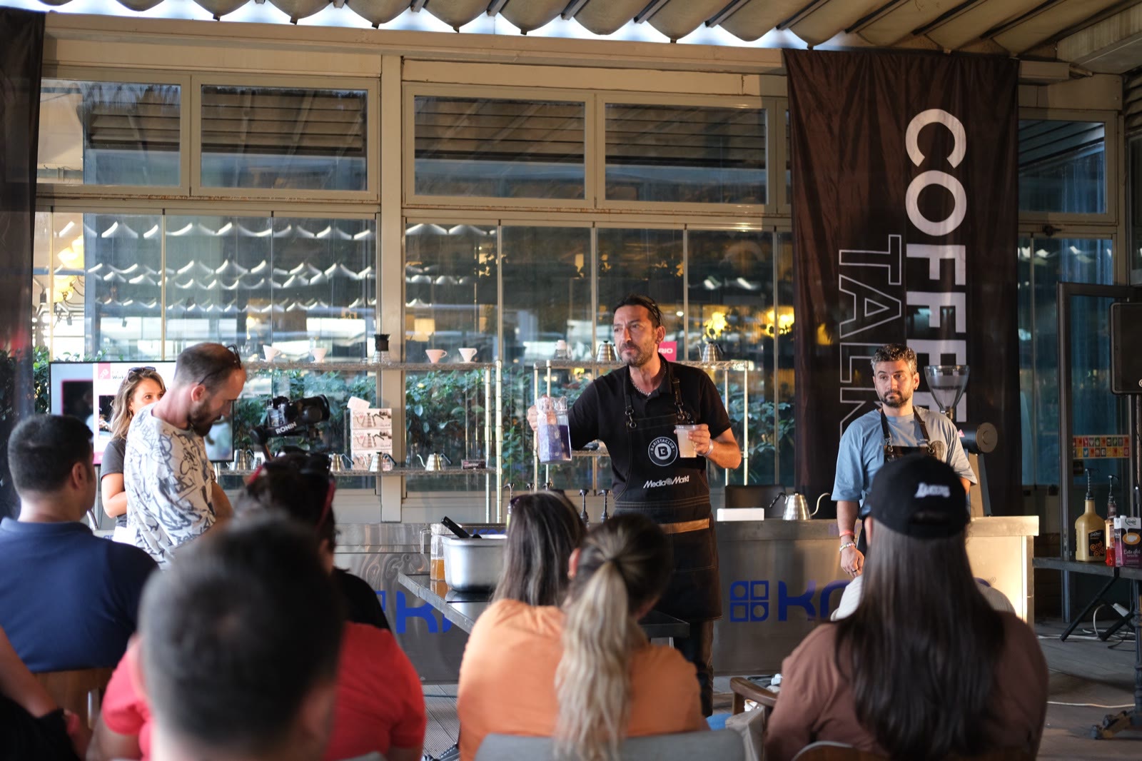 A barista explaining a brew to the audience at Coffee Talks