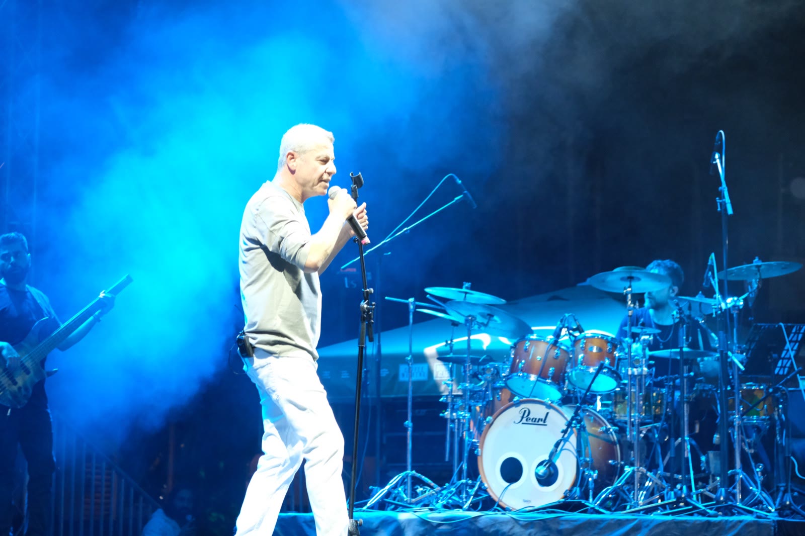 A singer at the microphone in blue stage light