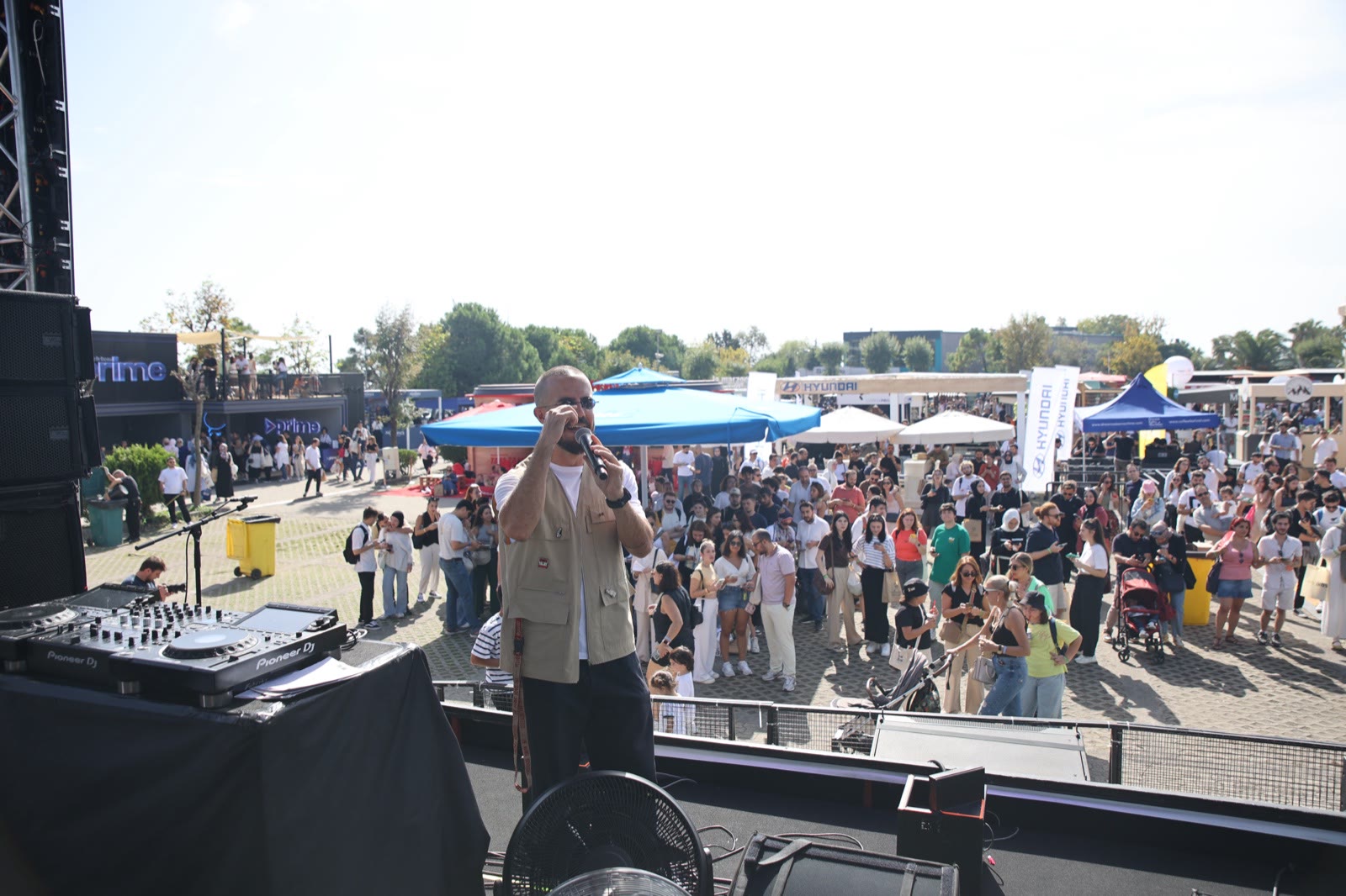 A host on stage addressing the daytime crowd
