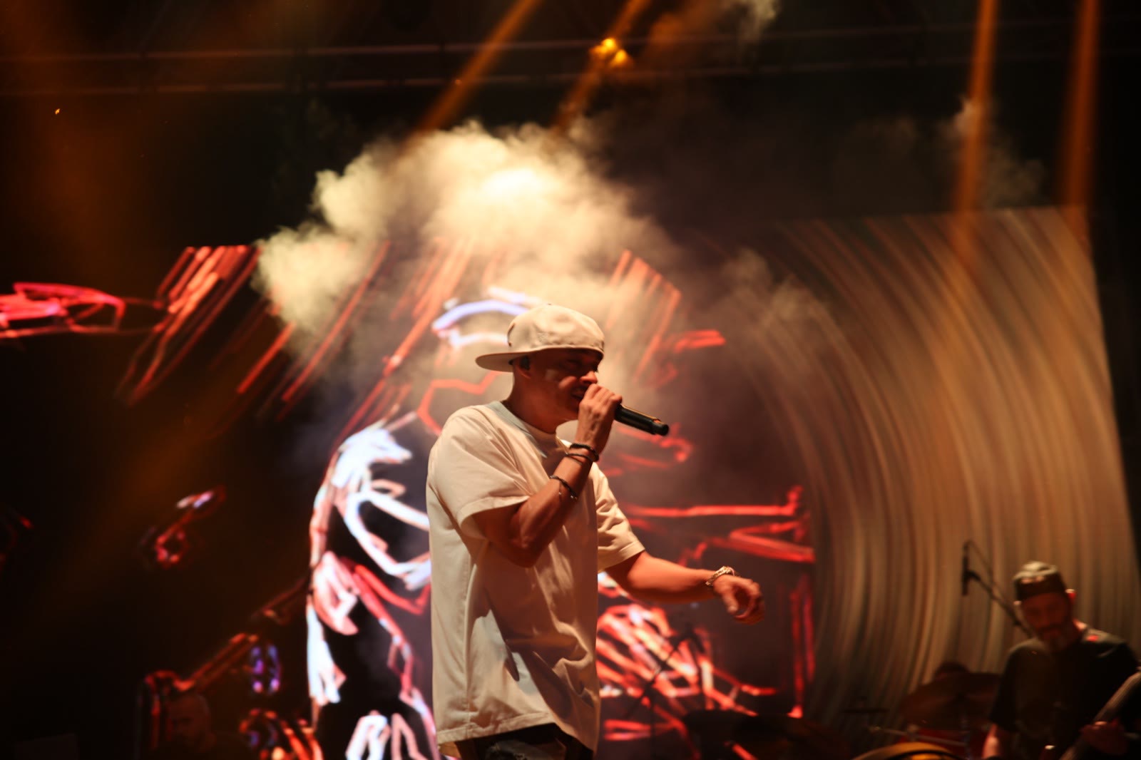 A rapper in a white shirt in front of the LED wall