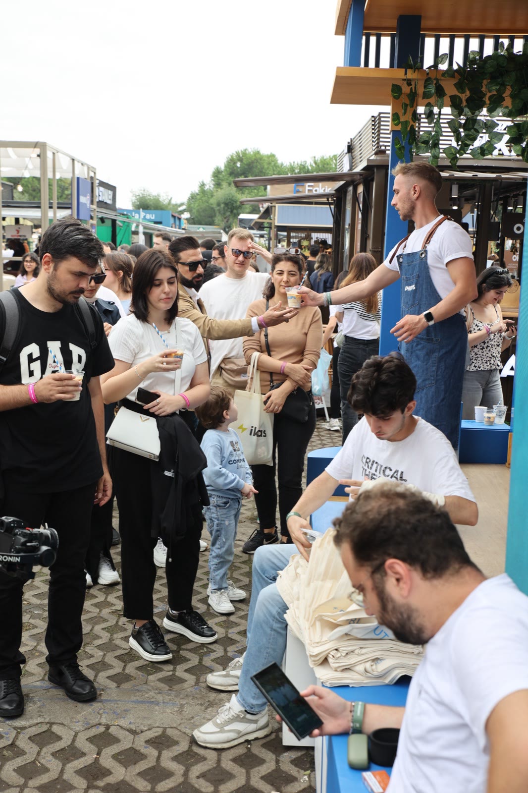 A barista handing a cup to visitors at a stand