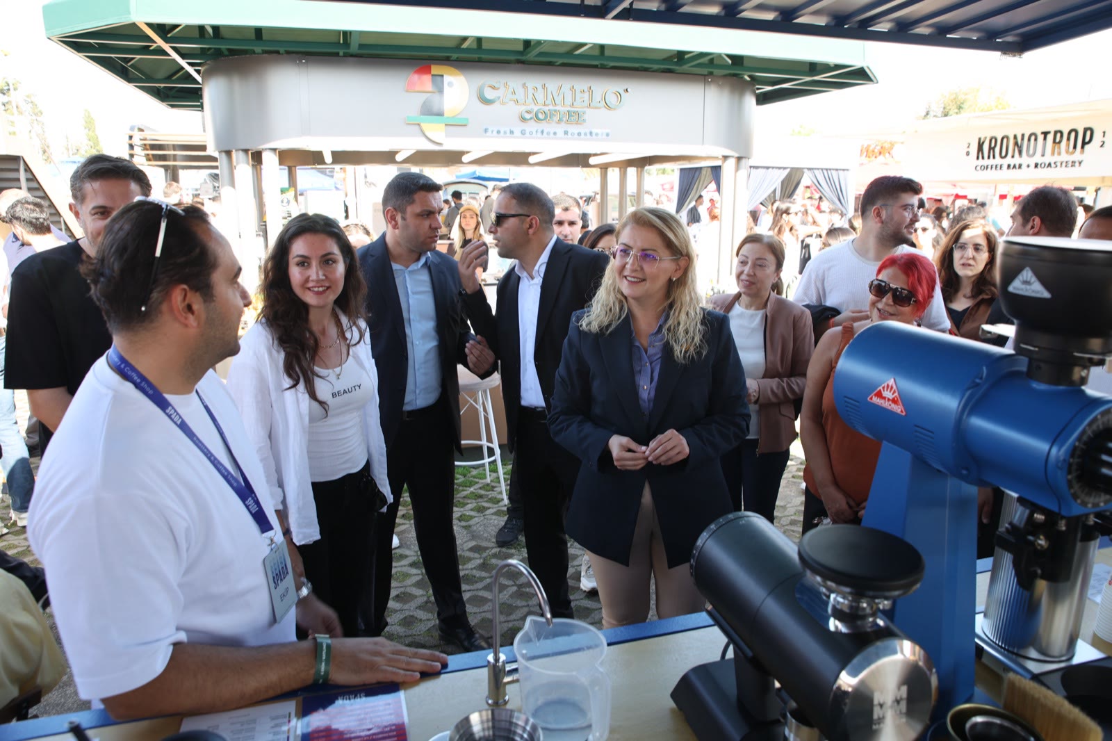 A delegation visiting a roastery's stand with grinders
